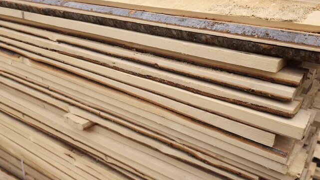 Wooden planks stacked at a lumber yard, showing different angles and arrangement of materials in a storage area