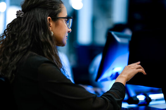 Senior software engineer debugging backend architecture code during agile sprint. Female developer reviewing syntax optimization strategy on digital screen.