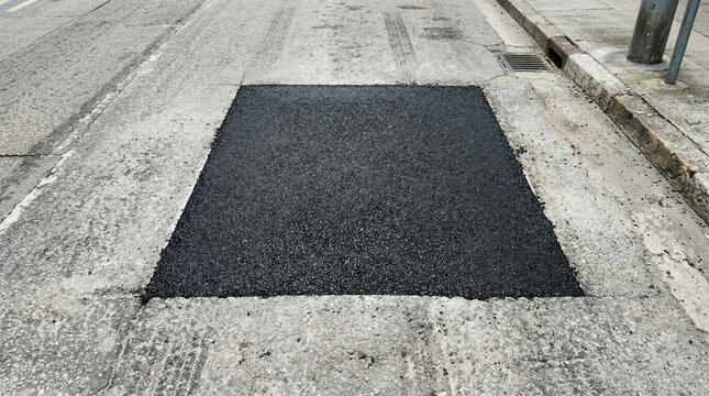 fresh asphalt patch on urban road for street repair and maintenance, city infrastructure renewal