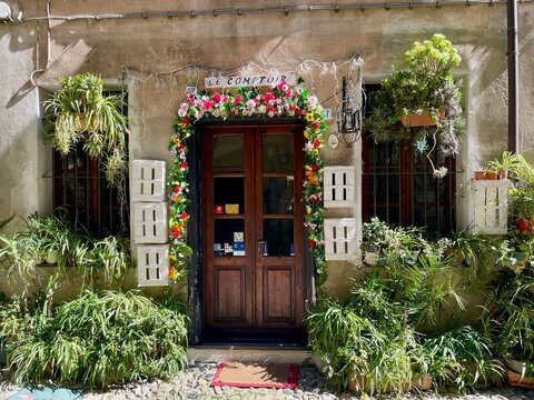 A charming street scene in Finalborgo, Italy, with colorful buildings and abundant potted plants, 30.03.2026.