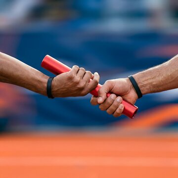 A close-up shot of the baton handoff in a relay race