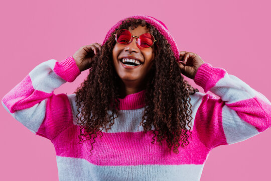 Fashion model wearing pink and smiling on pink background