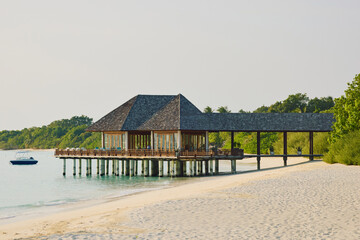 Fototapeta premium Classic Maldives island landscape on a sunset, azure water, white sand, palm trees on the shore