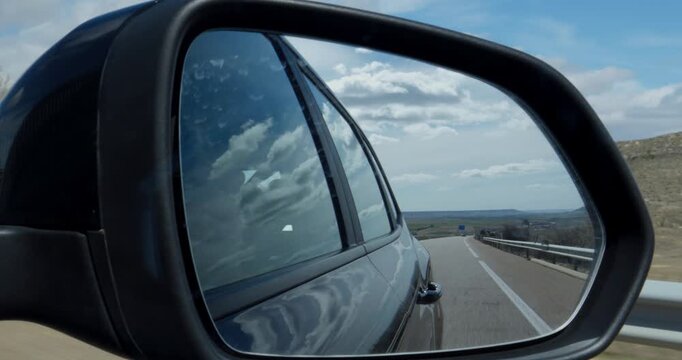 Car Rearview mirror Point of View of the passengers seat driving on an empty road