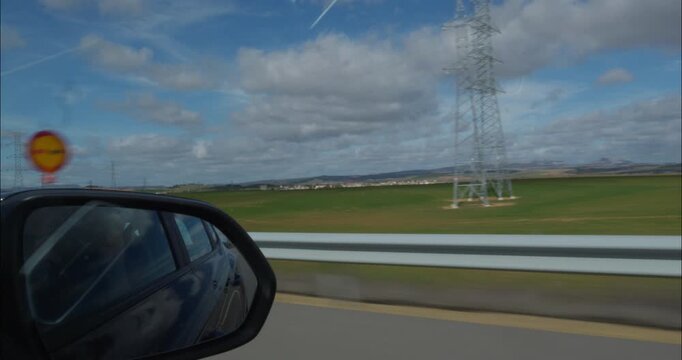 Rearview mirror POV from inside a car by the roads of Spain