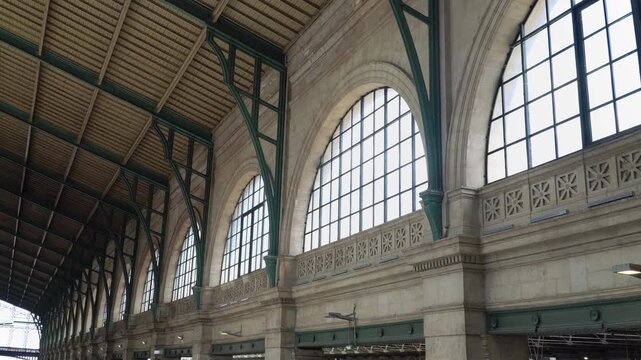 Green cast iron roof structure and arched glass windows of Gare du Nord station, Paris, France.