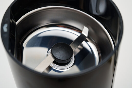 Coffee grinder sits on white surface ready for use in the kitchen