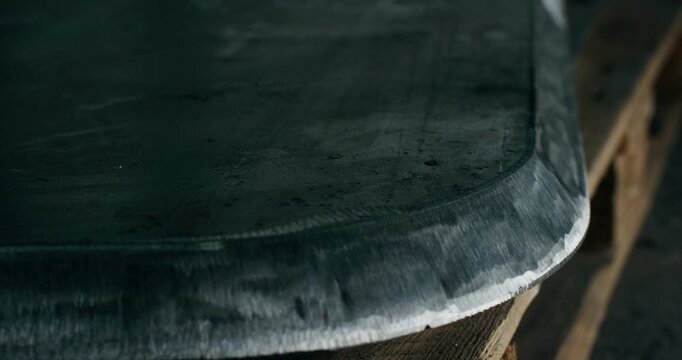 Close up of the beveled edge of a thick steel plate after grinding in an industrial workshop