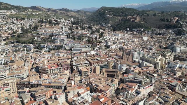Drone reveals a sunny aerial panorama of Granada historic city center in Andalusia, southern Spain.