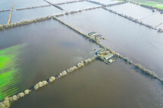Flooding disaster impact on rural farmlands with a bright green field visible