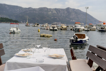 Dinner on the seashore. Beautifully set table in the harbor by the water. Romantic concept....