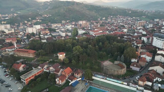 Ascending drone uncovers the medieval fortification and its green park in the heart of Novi Pazar, Serbia.