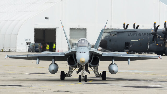 F-18 Hornet prepares for takeoff on the runway under clear skies at an airbase during a sunny afternoon in late spring