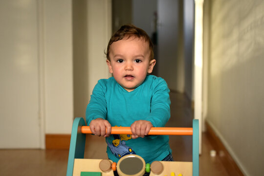 young child taking their first steps with a walker