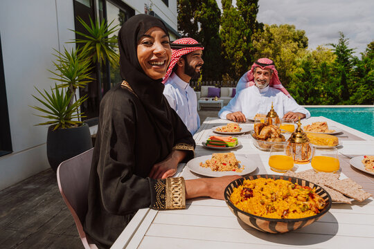 Muslim family enjoying festive meal together outdoors