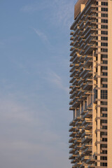 Fototapeta premium Modern skyscraper facade detail in Dubai. Close-up of glass windows and balconies of a luxury residential building, architectural pattern and contemporary urban design.