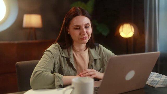 Woman Working Happily Remotely. Cheerful Woman Using Her Computer To Help Clients Remotely. Contented Female Professional Engaging In Customer Support Through Her Home Computer Setup