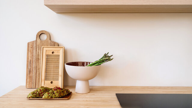 Kitchen with fresh asparagus, croissants, induction hob on countertop