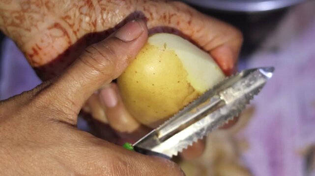 Authentic process of grating raw potatoes to create the base filling for crispy Indian potato bonda.