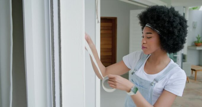 African American woman reaching pull cord pulling masking tape taping frame inspecting, copy space