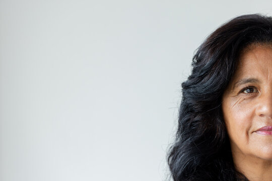 Mature African female posing and looking toward camera in studio showing wavy hair, copy space