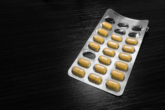 Yellow medical tablets in an open blister. Treatment and medication concept