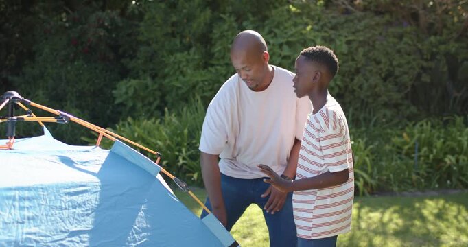 Dad and son building camping tent, adult inspecting pole, fixing seam, AR guides showing alignment