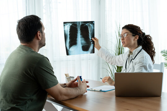 Doctor shows results to old patient x-ray of the lungs, smoking cigarettes problem. 