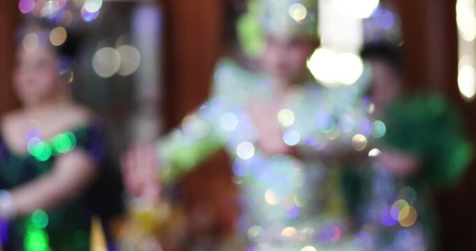 Blurred Thai Likay dancers performing traditional dance on stage with colorful bokeh lights. Cultural performance representing Thai heritage, festival entertainment and nightlife
