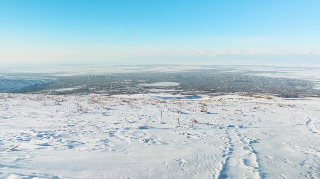Approaching Karakol with a drone over snowy fields in late autumn