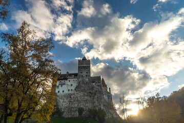 Obraz premium Bran castle fortress standing tall under dramatic autumn sky