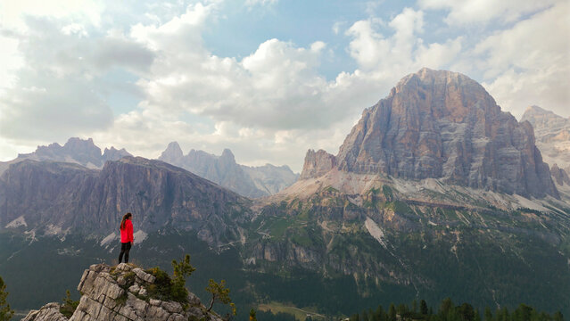 Hiker woman standing on mountain peak dolomites enjoying view