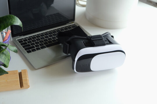 Computer with blank screen and virt ual reality glasses with headphones