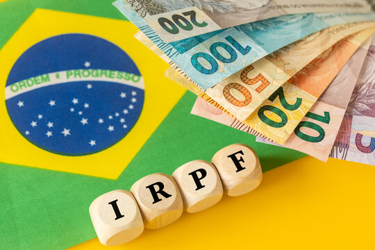 IRPF, Imposto de Renda de Pessoa F&iacute;sica, English translation Personal Income Tax. Financial concept. Taxes in Brazil. written on wooden blocks, Brazilian money, calculator, business background