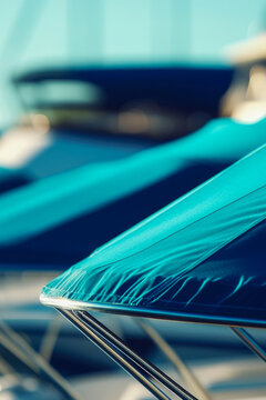 A group of blue umbrellas sit atop a boat, perhaps at a beach or lake. vertical frame