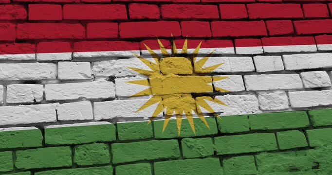 A panning video of a brick wall with the kurdistan flag