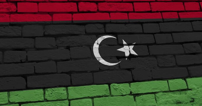 A panning video of a brick wall with the libya flag