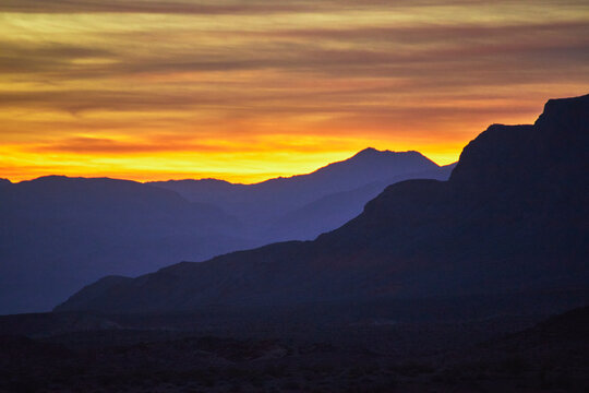 Sunrise Mountain Silhouettes and Colorful Sky Over Desert Valley Landscape