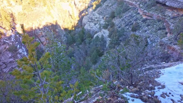 Aerial panorama shows Walnut Canyon landscape covered in snow under bright sunlight in Arizona