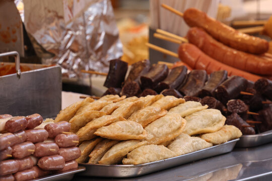 Assorted Korean Street Snacks Including Tteokbokki, Sausages and Mandu