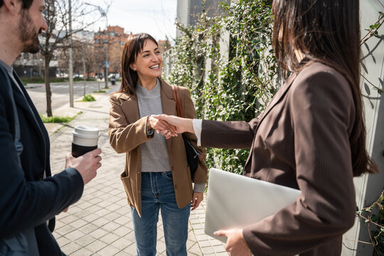 Businesswomen handshake outdoors near office building