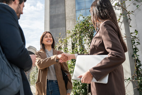 Businesswomen handshake outdoors near office building