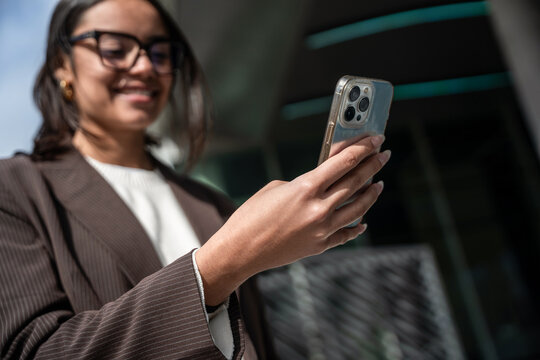 Businesswoman using smartphone outside office building