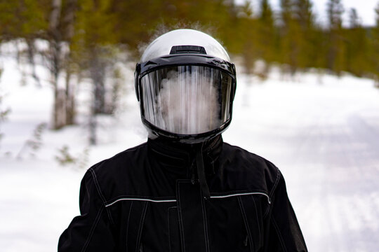 Snowmobile rider in winter forest landscape, Finland