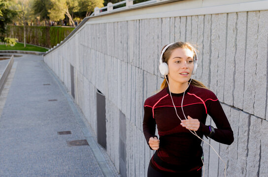 Woman running outdoors enjoying music in headphones