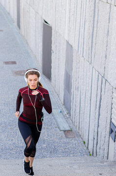 Woman running on urban path with headphones
