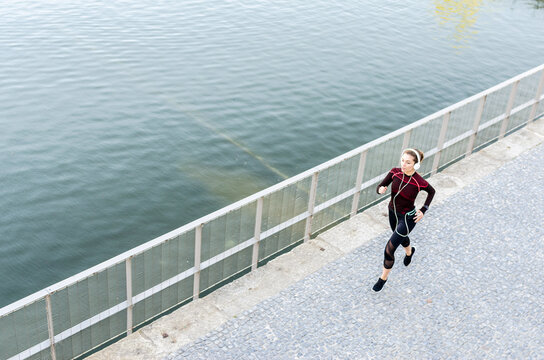 Woman jogging by the river on a sunny day
