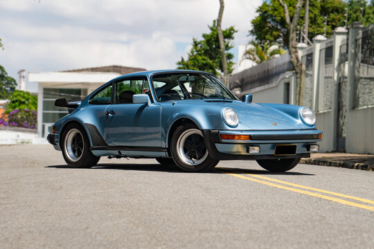 Blue Porsche 930 Turbo front three quarters, Classic sports car parked on city street
