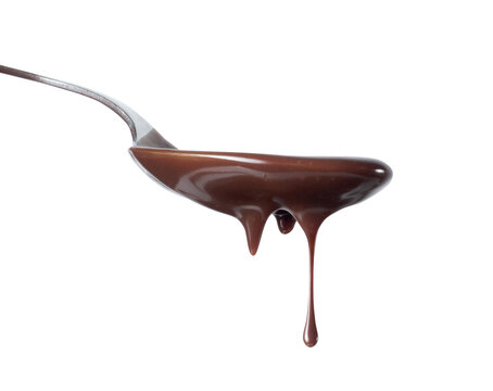 Chocolate syrop dripping from spoon close-up on a white background