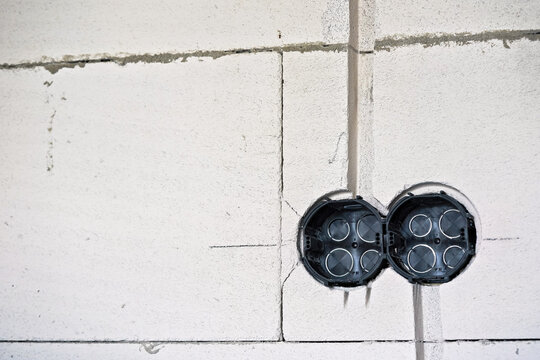 Empty electric power socket boxes at bare wall of new house construction site